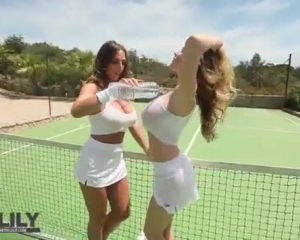 एक घास के स्तर पर टेनिस खेलते युवा लड़कियां।